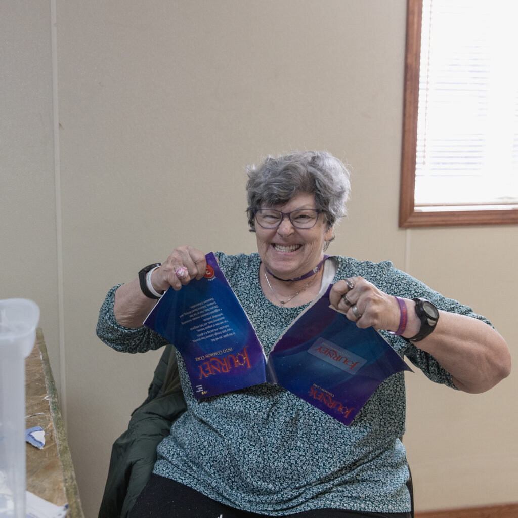 A woman rips apart bound documents, magazines, and books before shredding them at TVDSI's Adult Day Center in Greenleaf, KS.