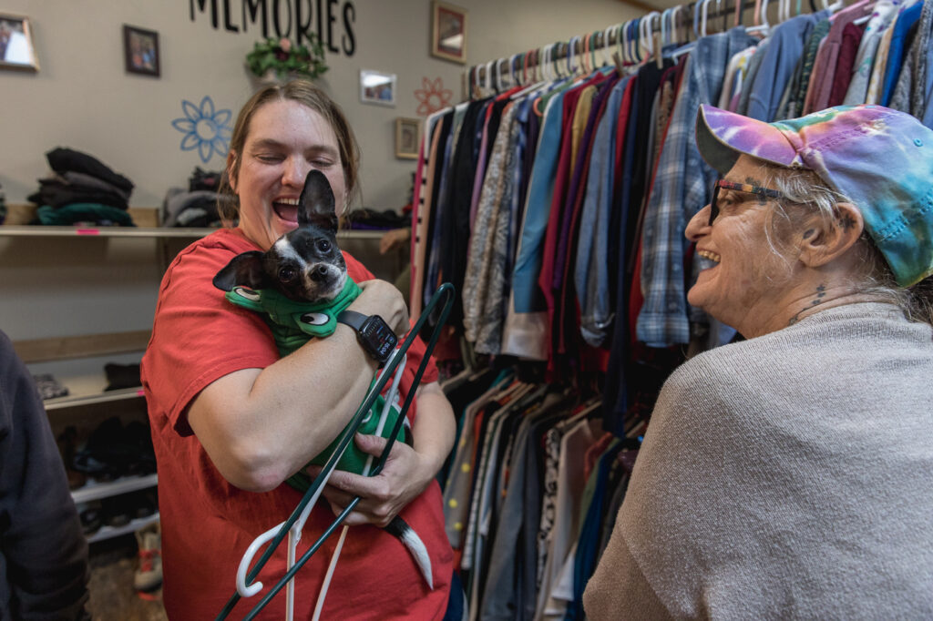 A woman with intellectual or developmental disabilities interacts with a customer and her pet at the Wearhouse Thrift Store in Waterville, KS. The thrift store provides job opportunities for adults with intellectual and developmental disabilities.